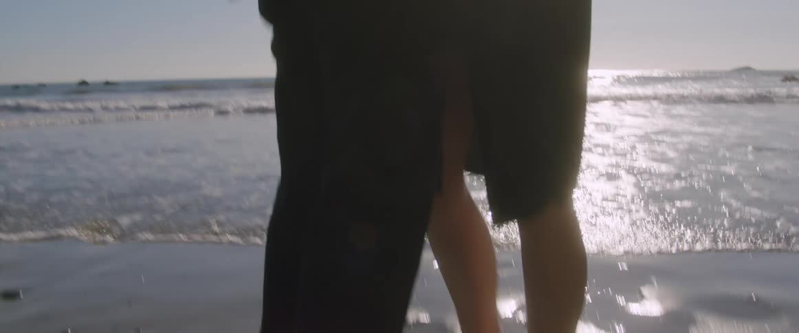 A man and woman dance on the beach