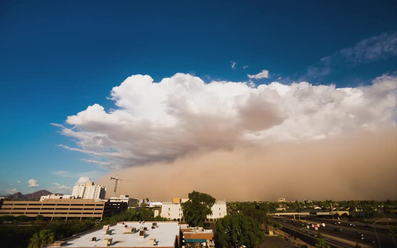 Large dust cloud flowing over a city