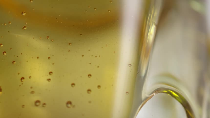 Close up of a glass filled with light yellow clear beer