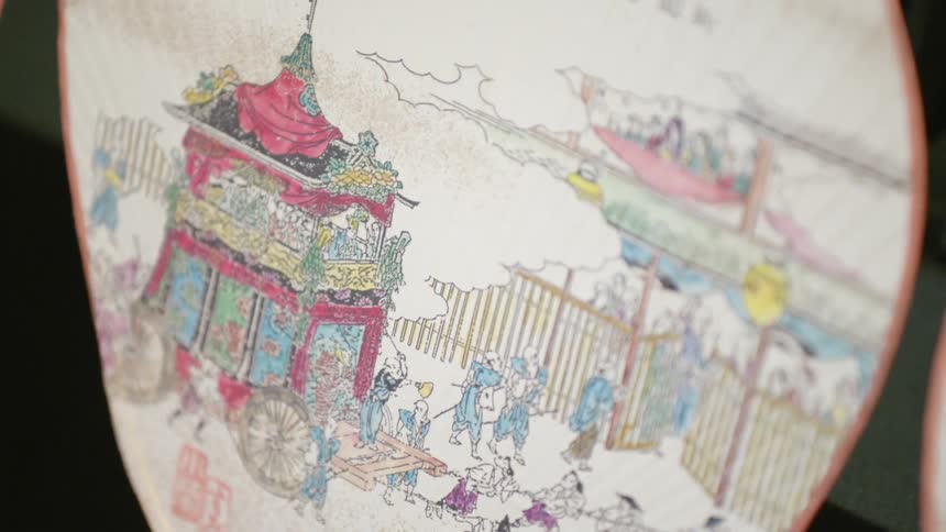 A painted chinese paper fan on display