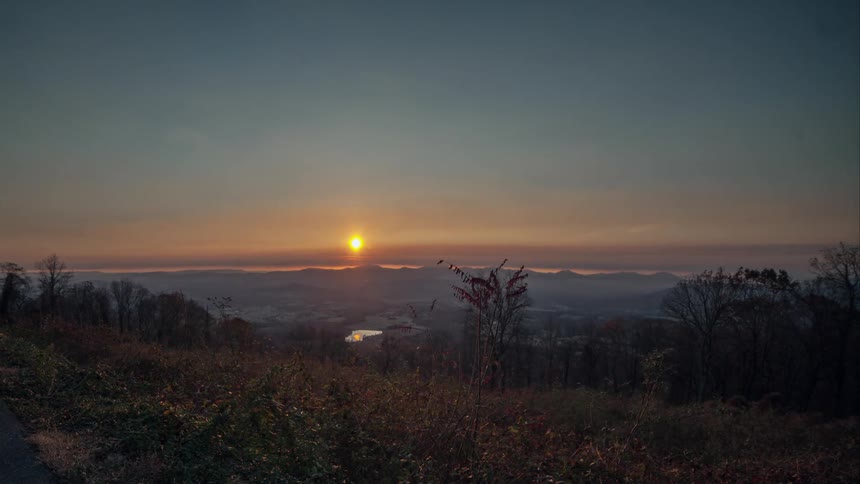 The sun rises over a snowy place