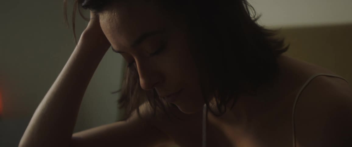 A sad woman holds her head in her hand