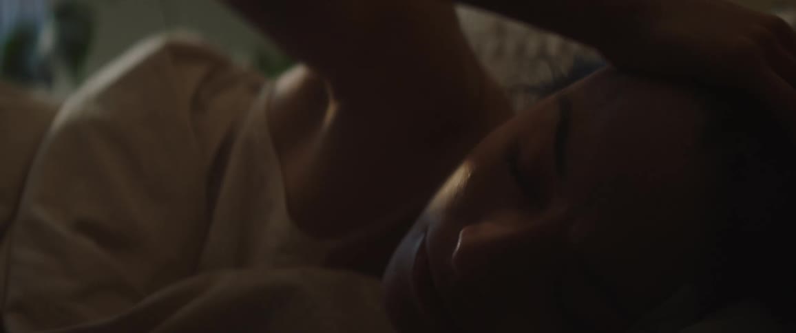 Woman stretches and turns in bed as she wakes