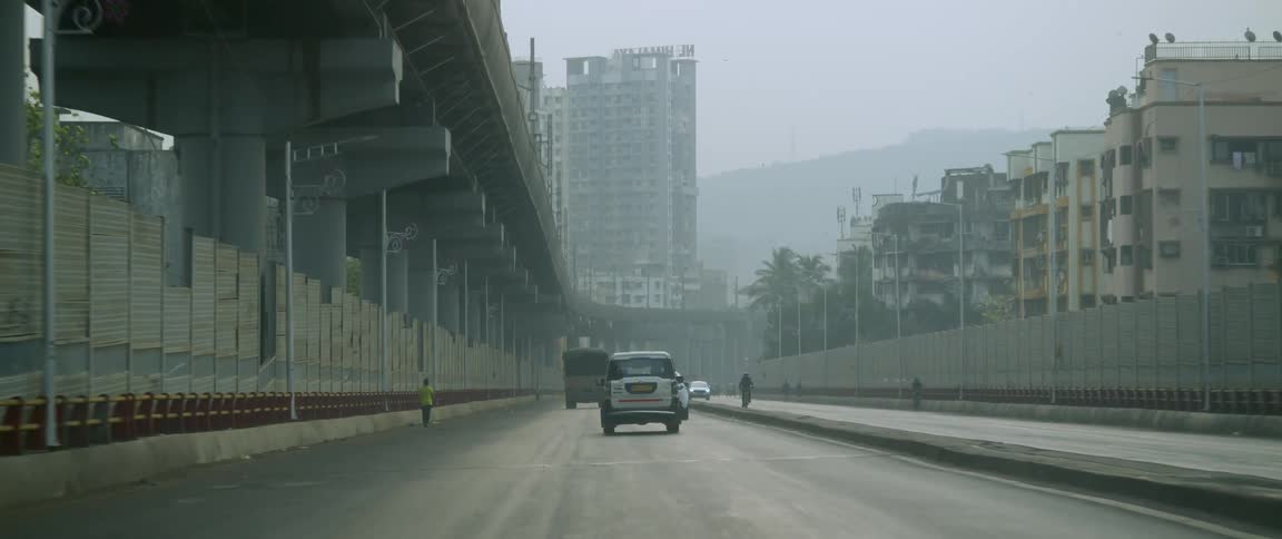 Several cars drive down a highway