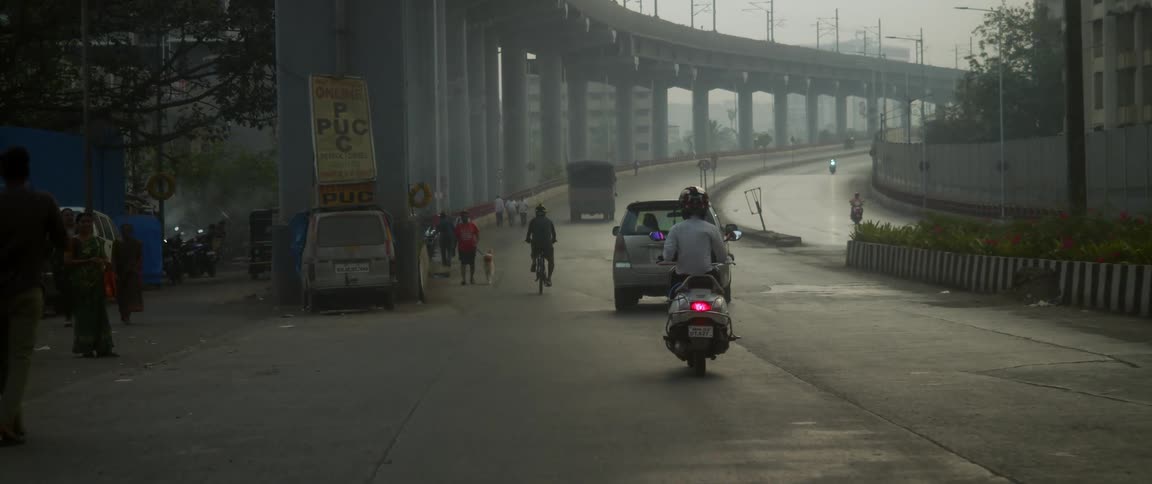 Cars are driving on a road through a city during spring