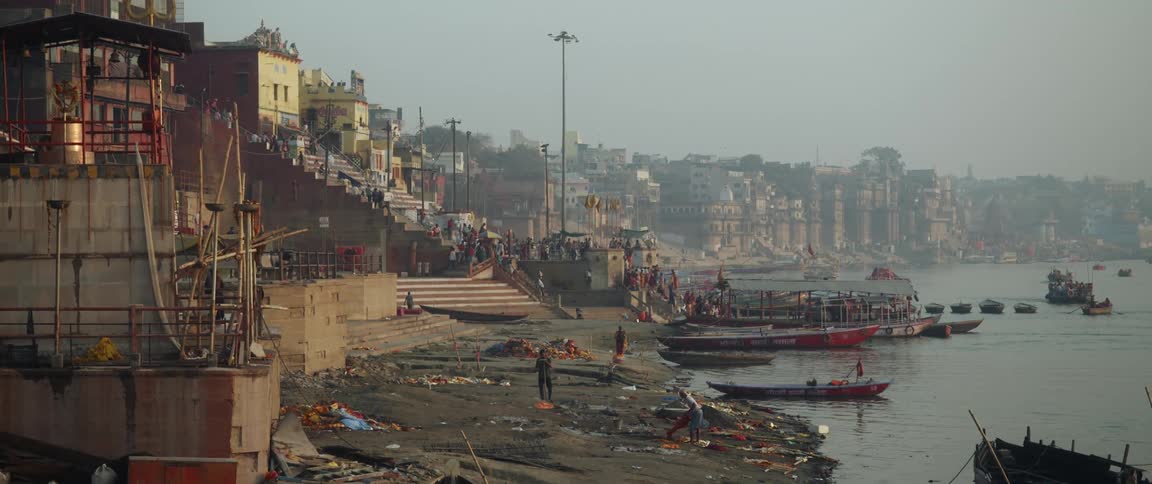 People move about and work on waterfront near town on foggy day