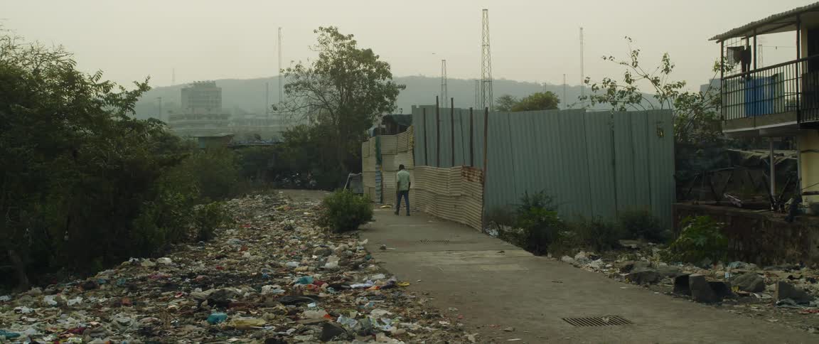 A man is walking past trash on the ground