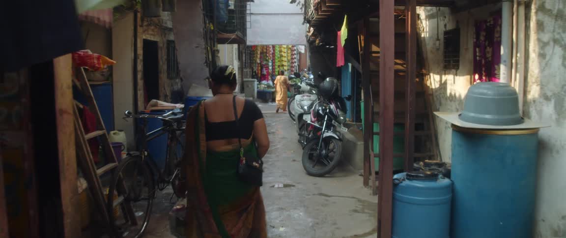 An older woman is walking down the streets of a small town