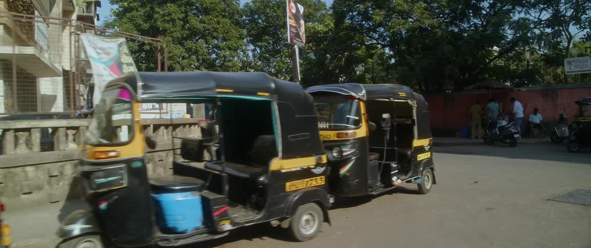 Carts and cars parked in an indian city street