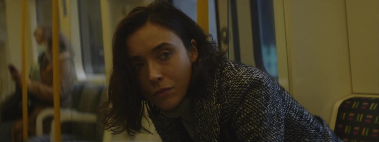 A young woman is on a city bus in the day time