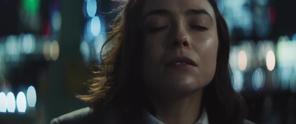 Close up of the face of a woman getting ready to dance on the city streets at night