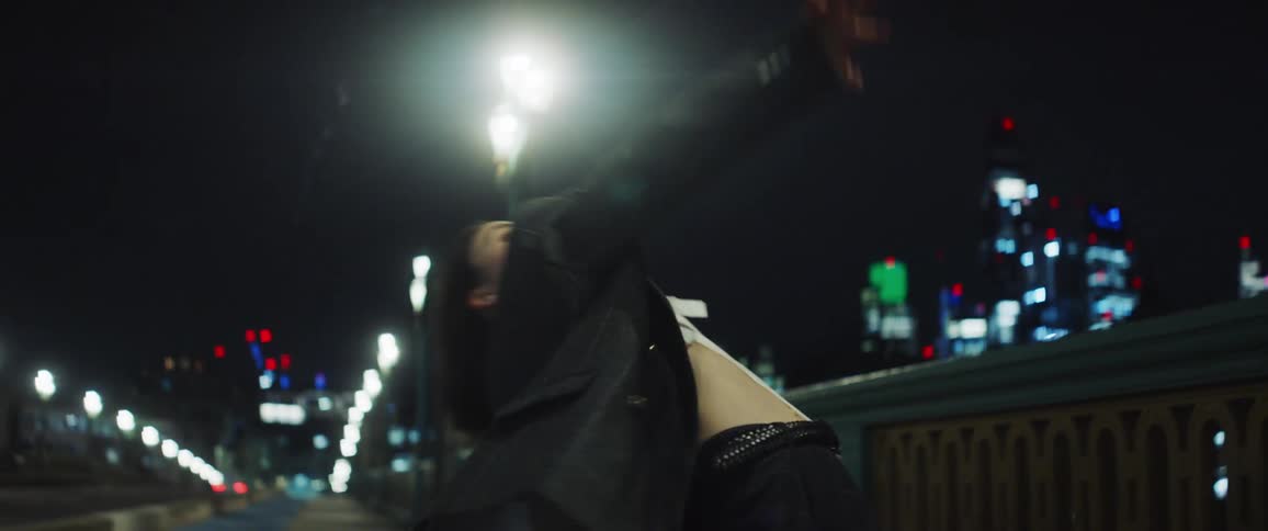 A young woman is dancing outdoors at night time