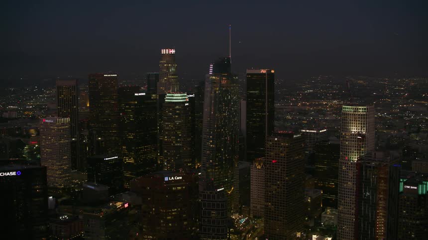 An aerial view of skyscrapers dominating a cityscape at night