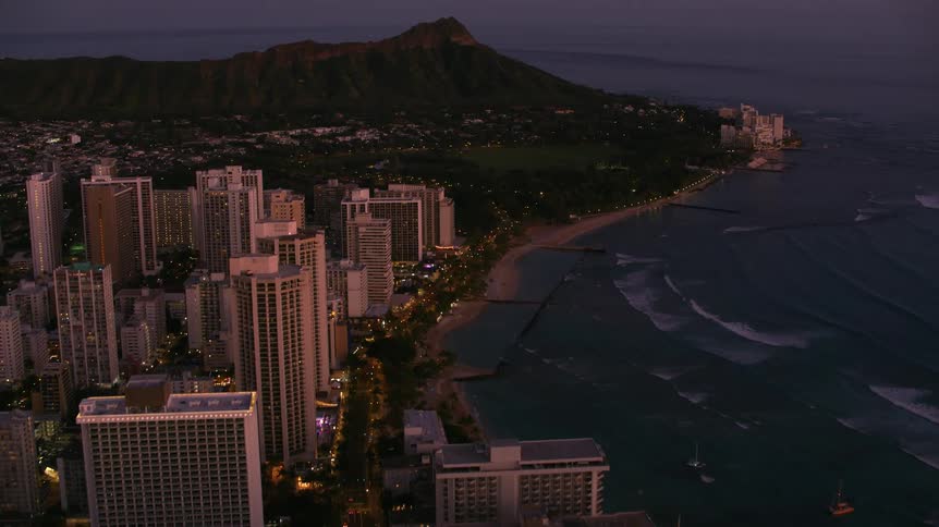A coastal city at night beside a mountain