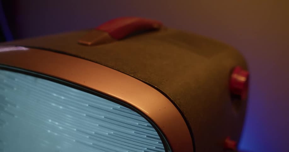 A retro television in a case with a handle screen playing static and light