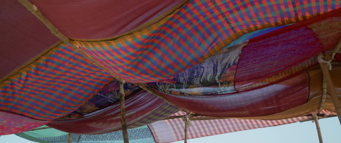 Cloth covering large open air pavilion structure flaps in the wind