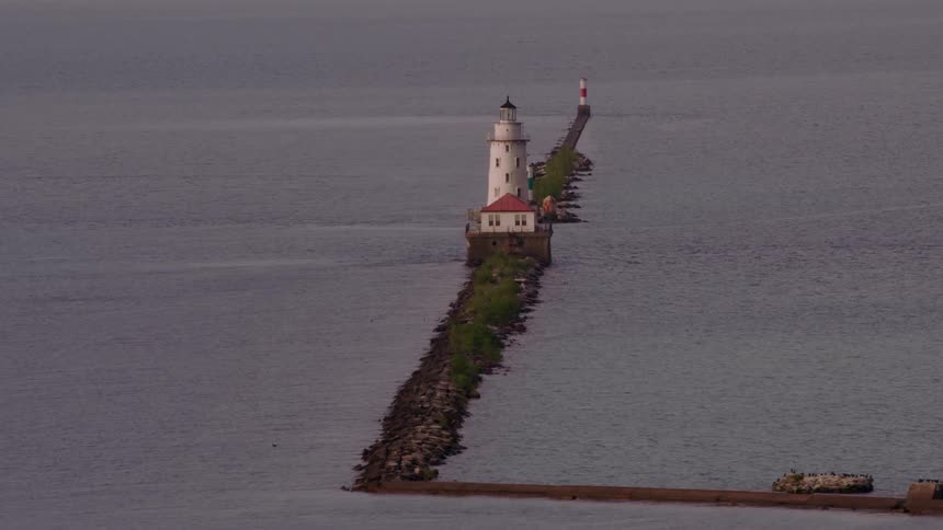 A lighthouse sits at the end of a long pier