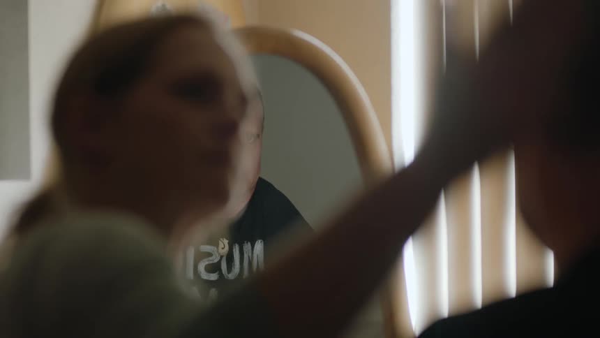 A woman fixes her husbands hair