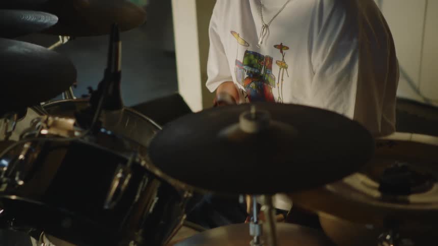Disabled man with sunglasses white t shirt and necklace plays drums