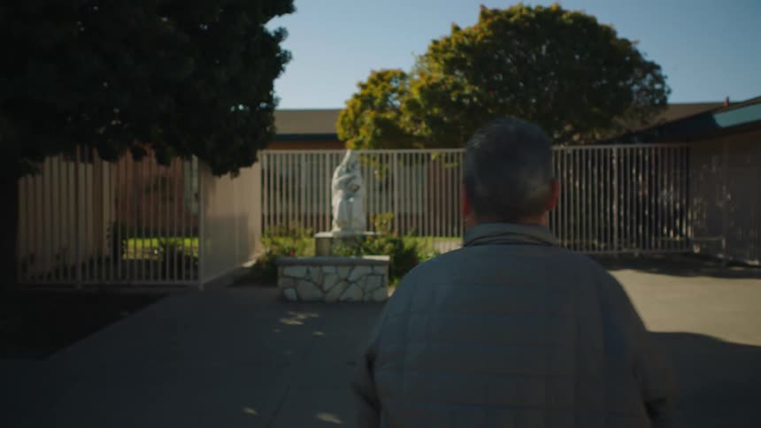 A man approaches a statue of a woman