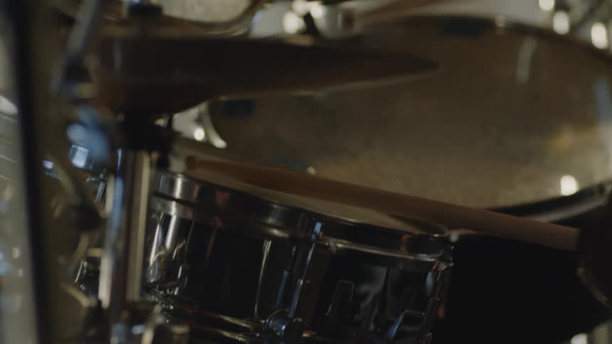 Man with white t shirt plays the drums