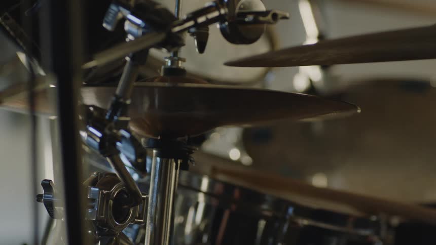 A view of drumsticks moving on drums and cymbals