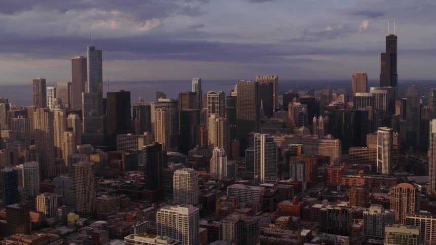 Skyscrapers loom over a metropolis in the evening