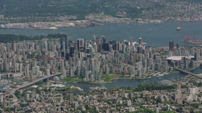 Watercrafts sit in river between downtown and residential area and in the harbor