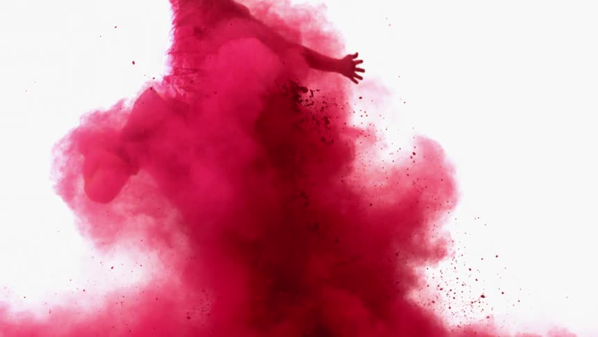 A man flies upward through the air in an explosion of red powder