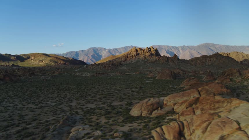 An aerial landscape of a mountain and desert landscape as the shadows are casted over the land