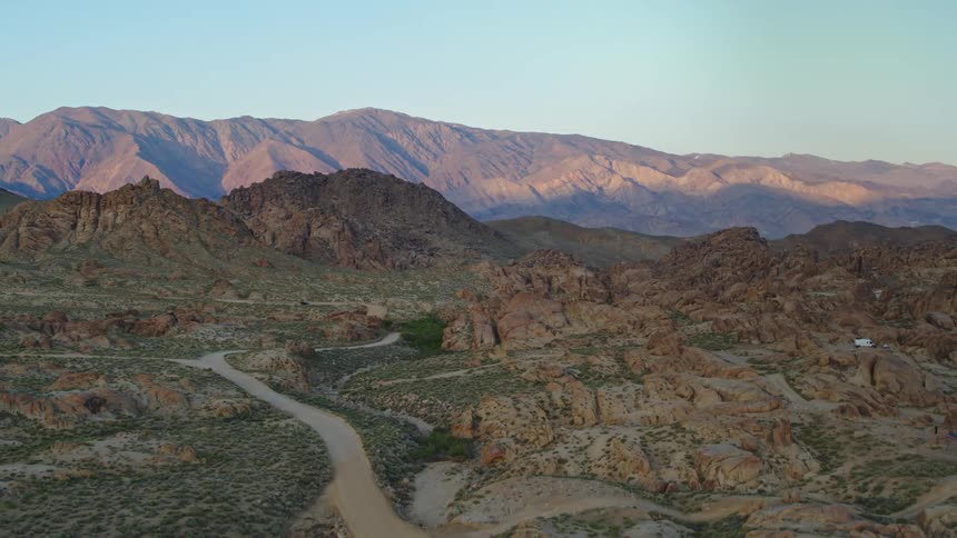 Aerial view of mountain and desert area sun is illuminating mountain range in the background late afternoon