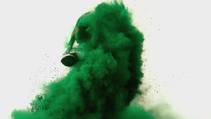 A male athlete does a flip in green powder