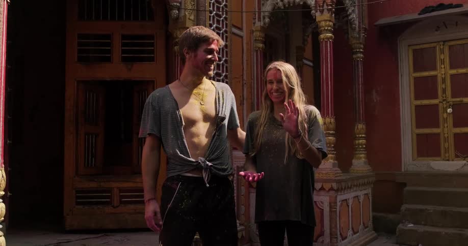 Young handsome happy couple smile while celebrating traditional indian spring festival holi