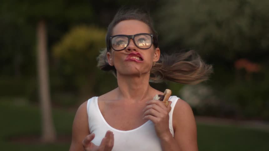 A strong wind contorts a woman's face in extreme slow motion
