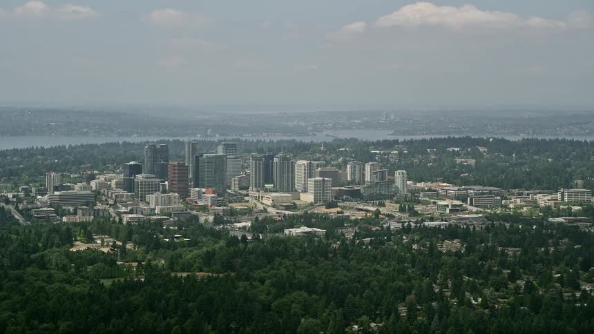 Aerial footage of Downtown Bellevues skyscrapers and city buildings amidst a hazy day