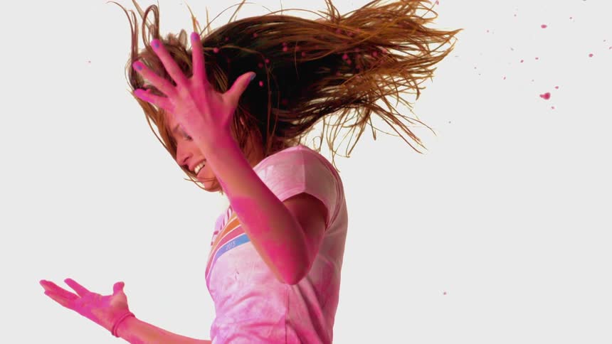 A woman is falling covered in pink powder