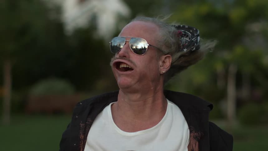 A strong wind contorts a man's face in extreme slow motion