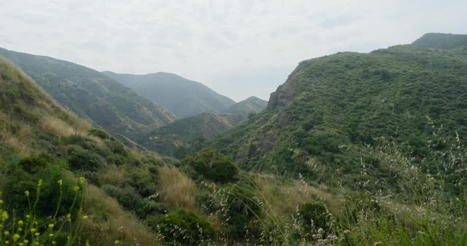 Mist covers mountains and valleys under cloudy sky