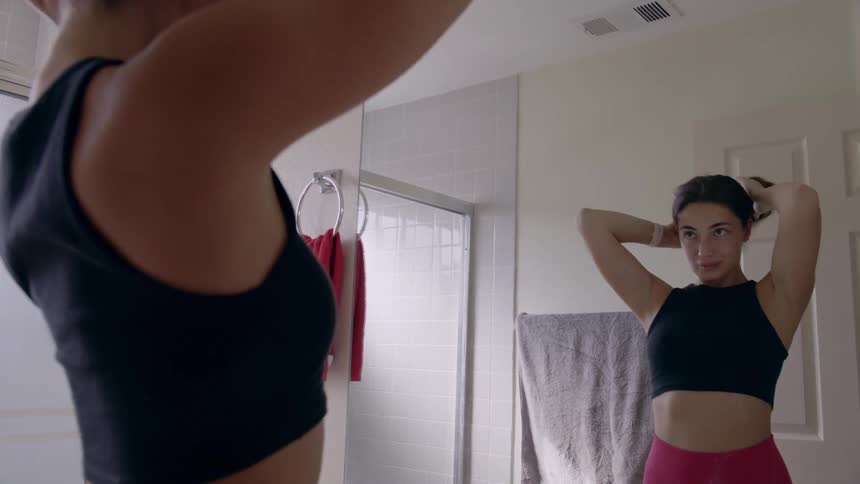 A young woman is inside of her bathroom in the day time