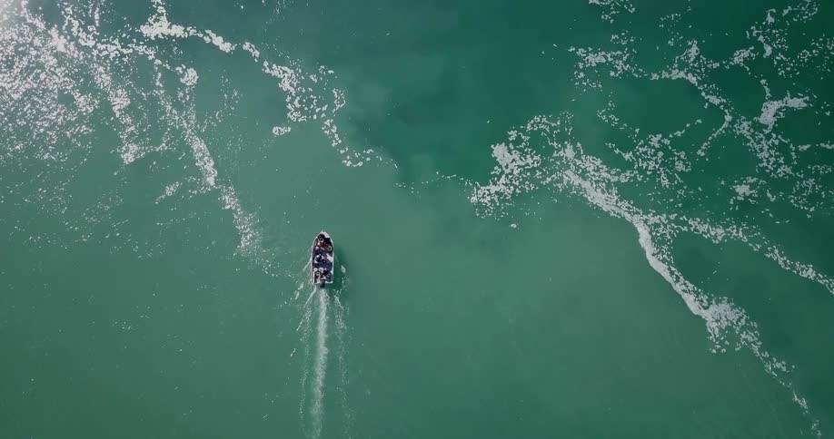A boat is sailing below filled with people