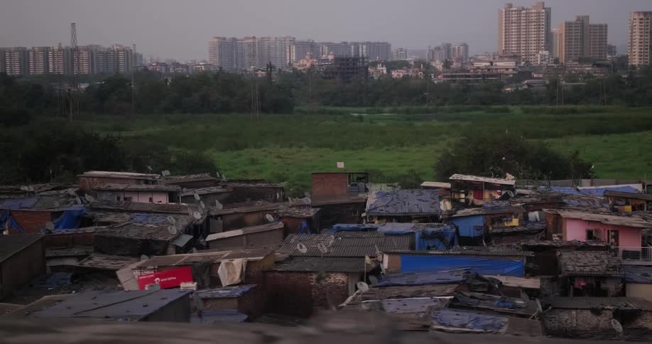 A slum with many shelters is outside the city