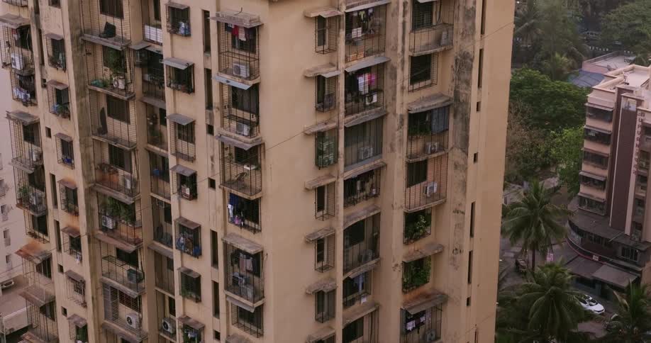 Grimy walled apartment building towers over nearby buildings
