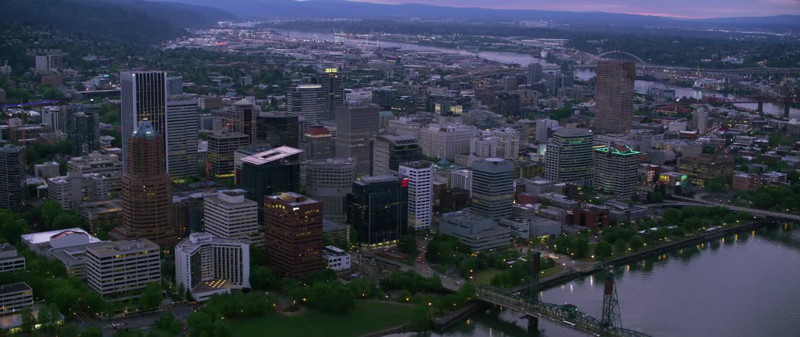 A cityscape by a river at dawn
