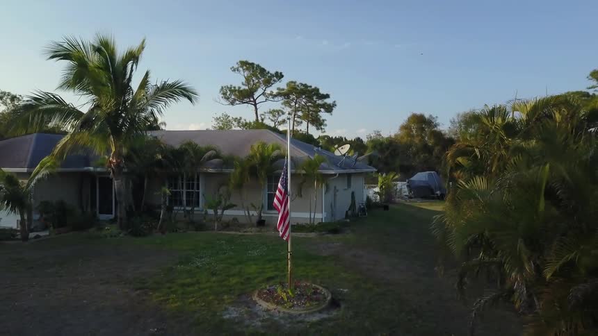 A u.s. flag blows slightly in the breeze outside a house