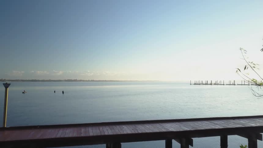 A wooden boardwalk is by the water ahead