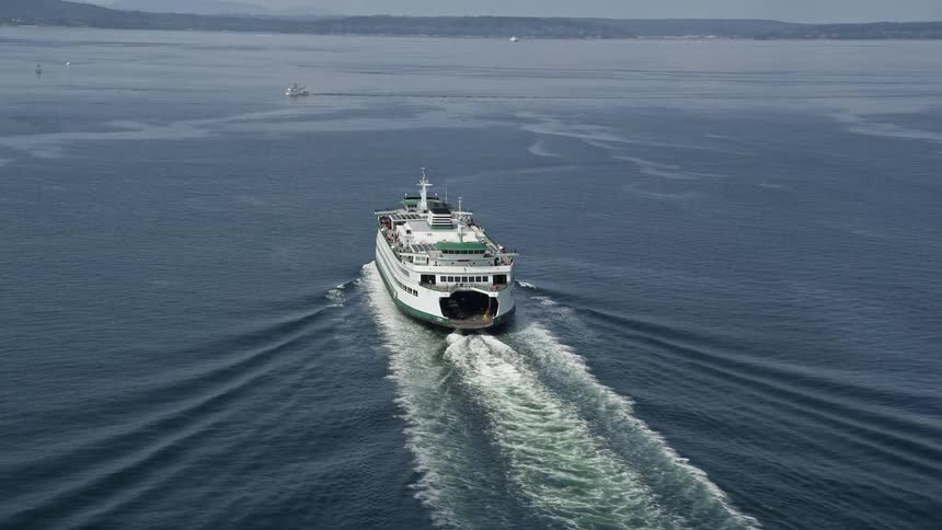 A ferry sails across Elliot Bay in Seattle WA under sunny skies