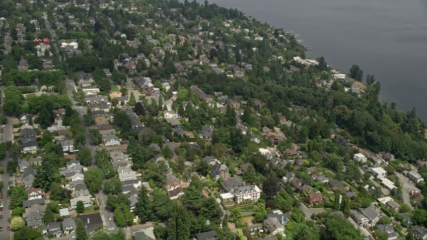 Aerial footage of a Madrona residential neighborhood in Seattle Washington with trees and light traffic on the streets