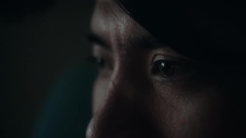 A closeup view of a womans face and eyes as she stares off into the distance