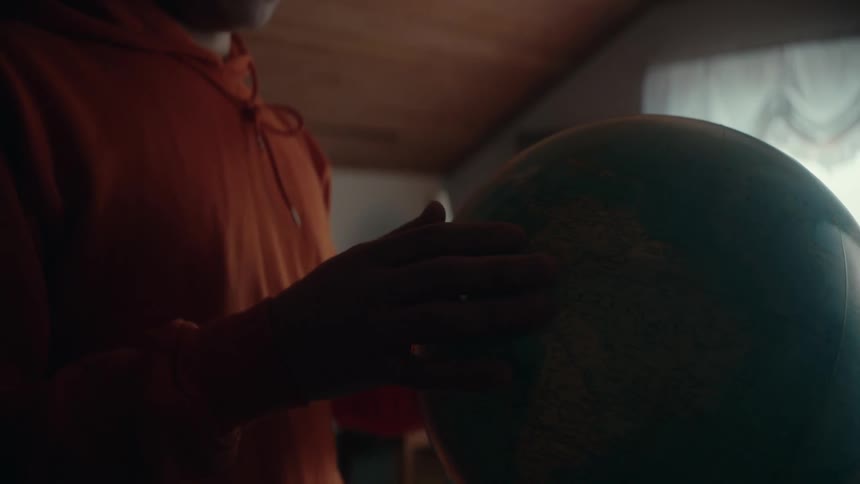 A teenager is touching the globe