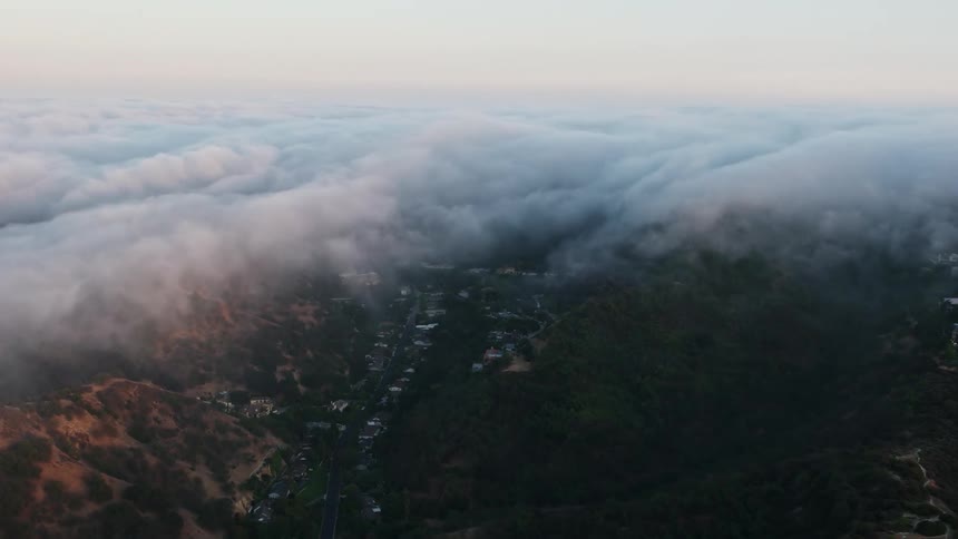 A stunning 4K aerial clip of a marine layer engulfing the hills and valley of Studio City California at sunset